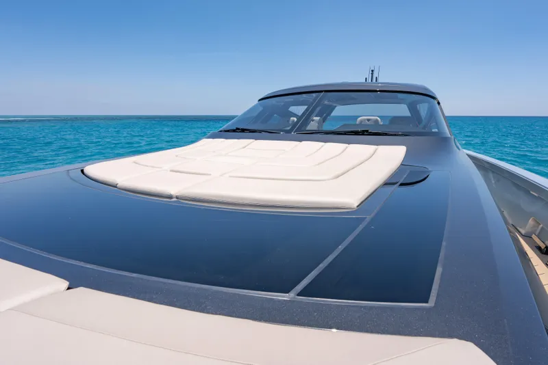 Slide: The Image of Luxury Wajer 77 yacht on clear blue ocean, showcasing sleek design and sunbathing area. - 38