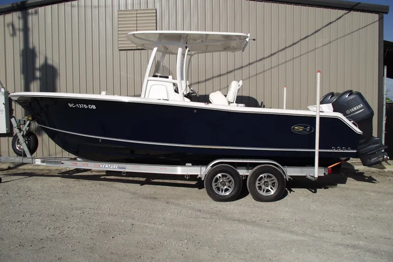 The Image of 2014 Sea Hunt Gamefish 25 boat on trailer, parked outdoors, side view. - 0