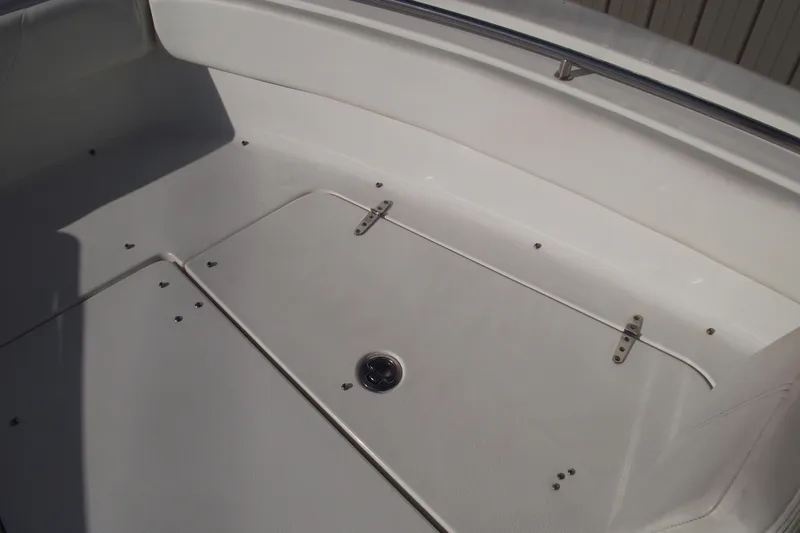 Slide: The Image of 2014 Sea Hunt Gamefish 25 boat interior, featuring a clean, white deck with storage compartment. - 11