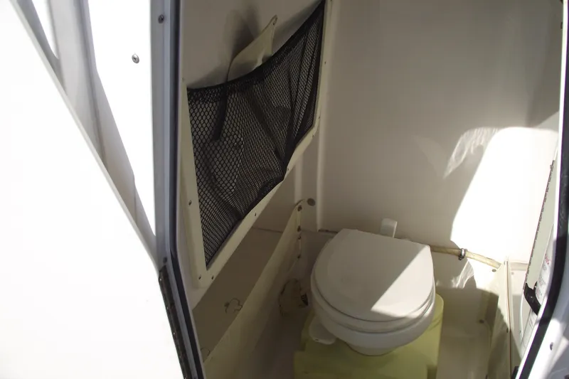Slide: The Image of 2014 Sea Hunt Gamefish 25 boat interior with toilet and storage netting. - 19