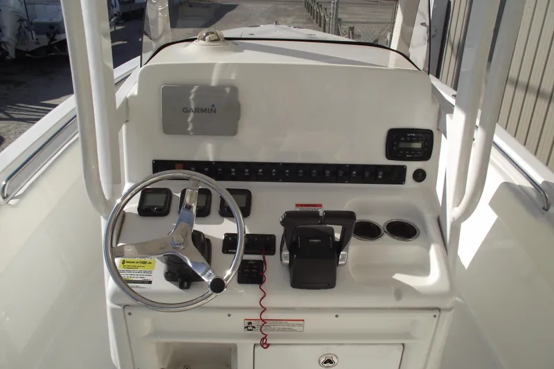 Slide: The Image of 2014 Sea Hunt Gamefish 25 boat console with Garmin navigation and steering wheel. - 21