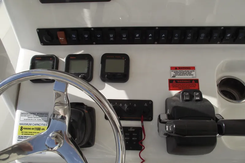 Slide: The Image of 2014 Sea Hunt Gamefish 25 dashboard with steering wheel, controls, and gauges. - 23