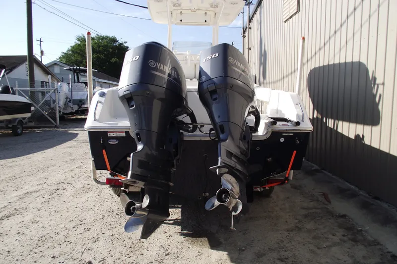 Slide: The Image of 2014 Sea Hunt Gamefish 25 with dual Yamaha 150 engines, parked outdoors. - 3