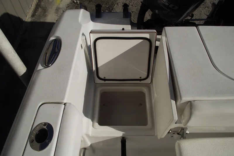 Slide: The Image of 2014 Sea Hunt Gamefish 25 boat storage compartment, open lid, white interior. - 35