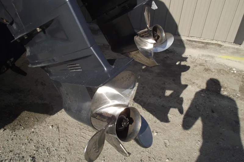 Slide: The Image of Twin propellers of a 2014 Sea Hunt Gamefish 25 boat on a gravel surface. - 5