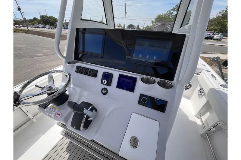 Slide: The Image of 2026 Tidewater 3100 Carolina Bay boat dashboard with steering wheel and modern controls. - 12