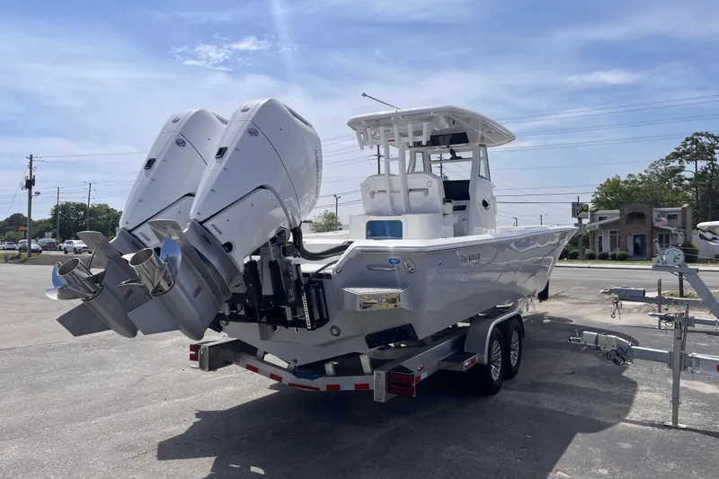 Slide: The Image of 2026 Tidewater 3100 Carolina Bay boat with dual engines on a trailer in a parking lot. - 6