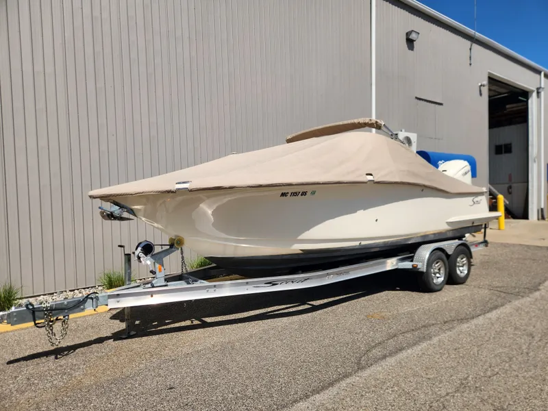 Slide: The Image of 2022 Scout 255 Dorado boat on trailer, covered, outside warehouse. - 7
