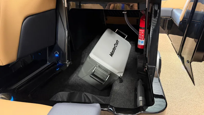 Slide: The Image of The interior of a 2027 MasterCraft NXT20 features a storage area with a fire extinguisher and cooler. - 42