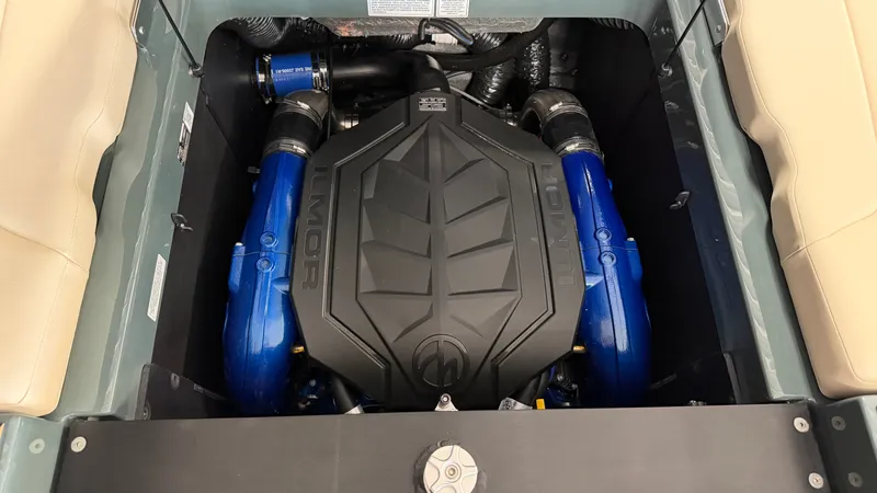 Slide: The Image of The engine compartment of a 2027 MasterCraft XT24 features a powerful engine with blue hoses. - 24