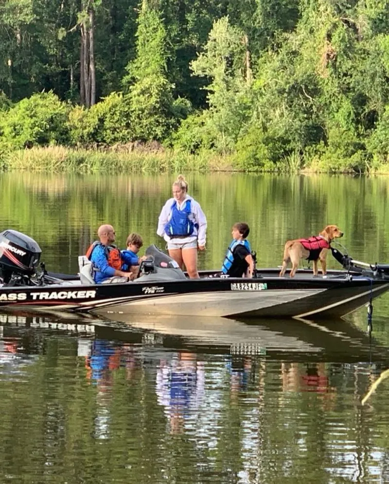 Slide: The Image of Family and dog on Bass Tracker Pro Team boat, 2008, on a serene lake. - 11