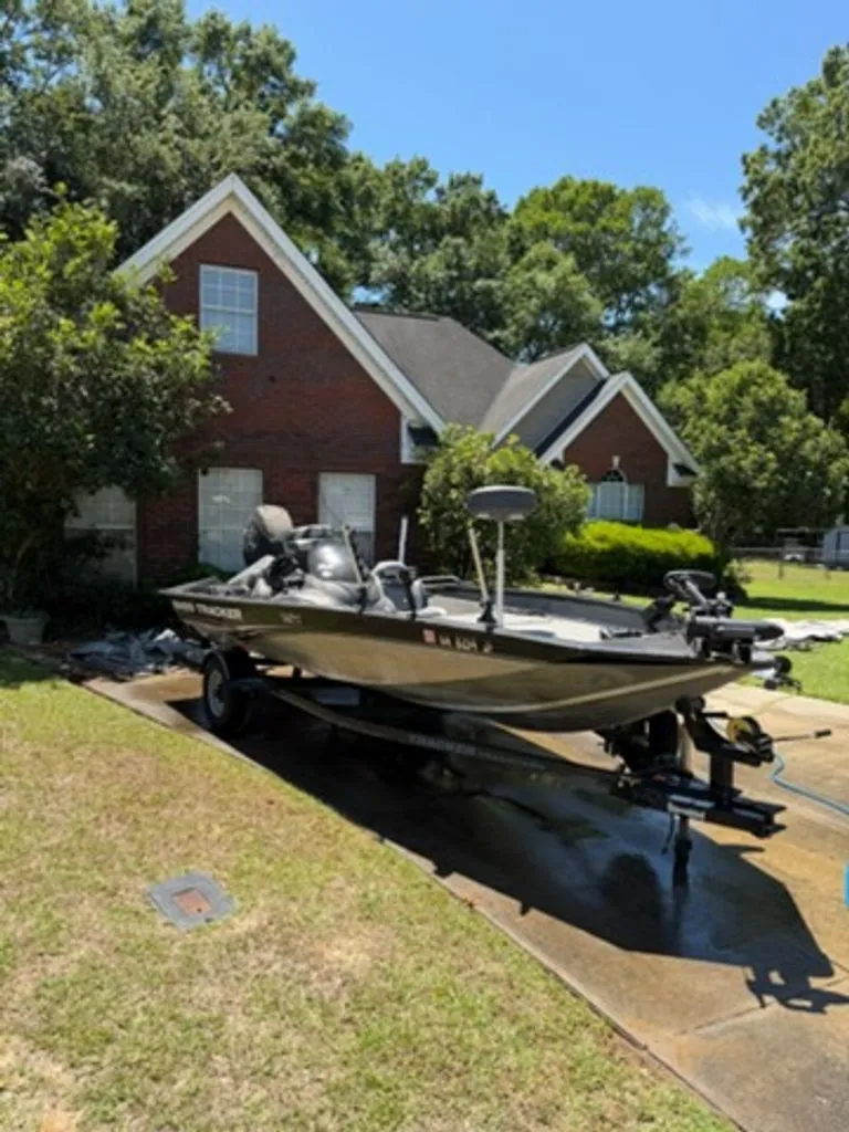 Slide: The Image of 2008 Bass Tracker Pro Team boat parked in front of brick house. - 2