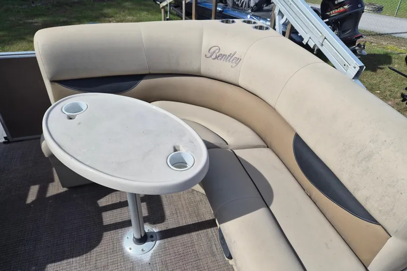 Slide: The Image of 2004 Bentley Pontoons 180 CRUISE interior with beige seating and oval table. - 10
