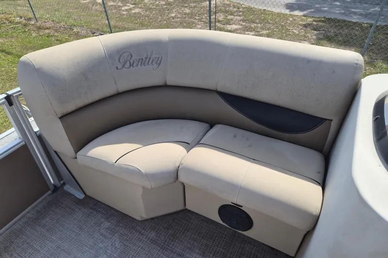 Slide: The Image of Bentley Pontoons 180 CRUISE 2004 boat seating with beige upholstery and logo. - 11