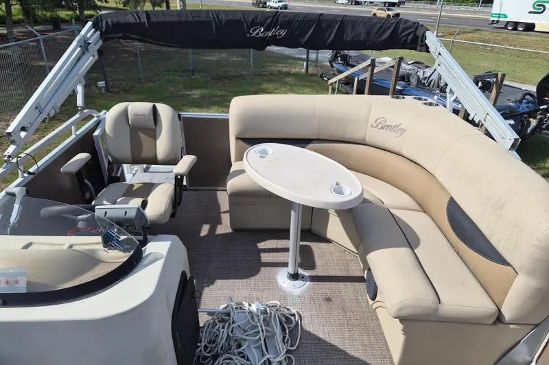 Slide: The Image of 2004 Bentley Pontoons 180 CRUISE interior with beige seating and table, showcasing comfort and style. - 13