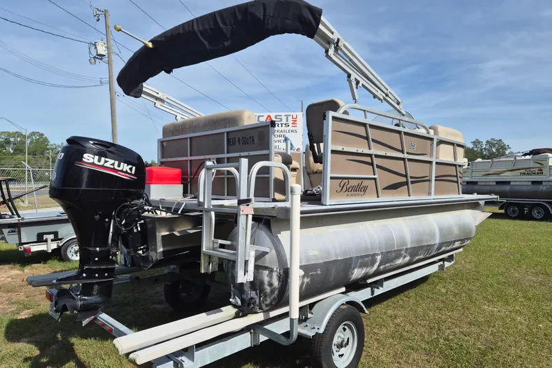 Slide: The Image of 2004 Bentley Pontoons 180 CRUISE on trailer with Suzuki outboard motor, parked outdoors. - 4