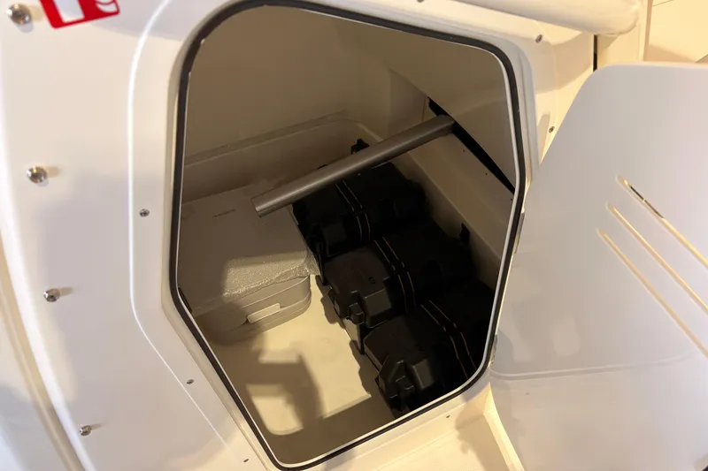 Slide: The Image of Storage compartment of 2026 Boston Whaler 220 Dauntless boat, featuring organized equipment. - 10