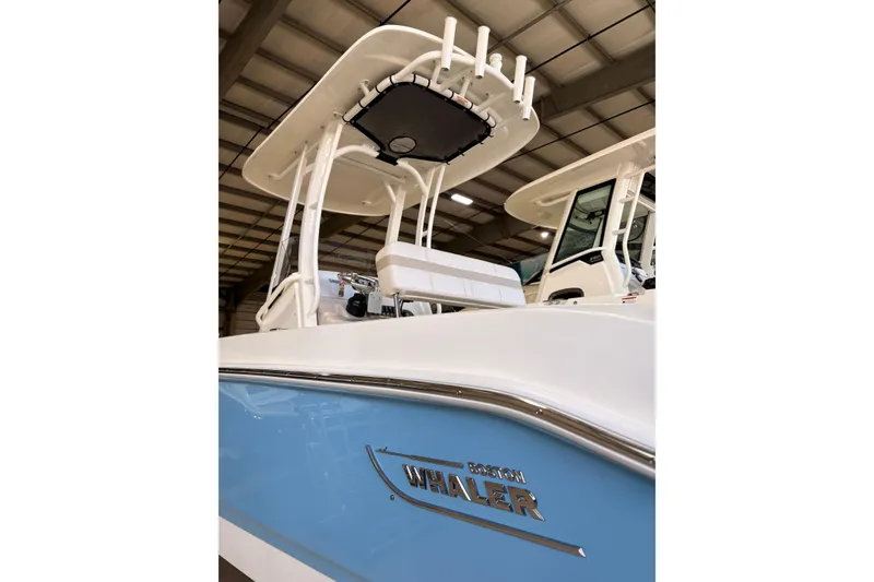 Slide: The Image of 2026 Boston Whaler 220 Dauntless boat in showroom, showcasing sleek design and modern features. - 4