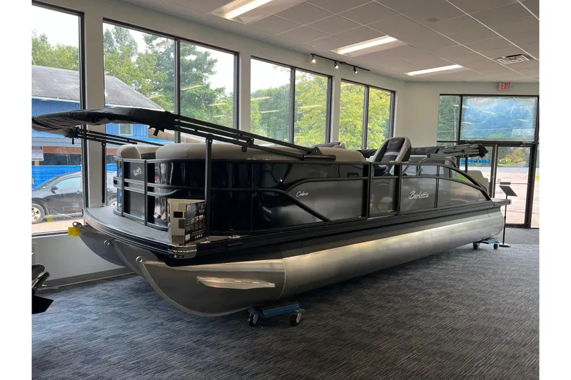 The Image of 2025 Barletta Cabrio 22UC pontoon boat displayed indoors with canopy and sleek design. - 0
