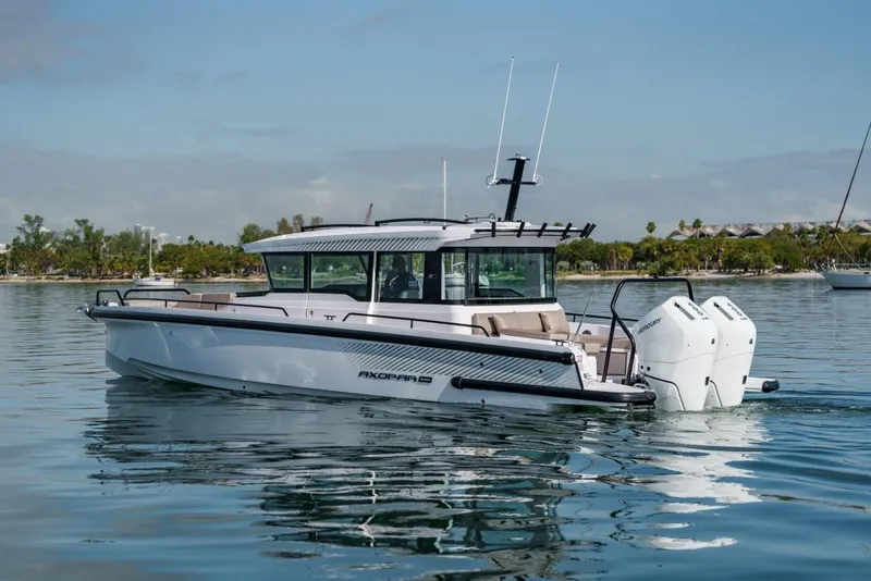 The Image of 2026 Axopar 37 XC Cross Cabin boat on calm water, showcasing sleek design and twin engines. - 0