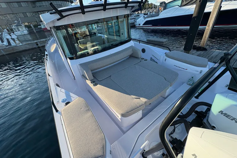Slide: The Image of 2026 Axopar 37 XC Cross Cabin boat with cushioned seating, docked at marina. - 64