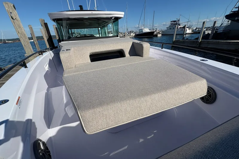 Slide: The Image of 2026 Axopar 37 XC Cross Cabin with sunbed, docked at marina under clear blue sky. - 28
