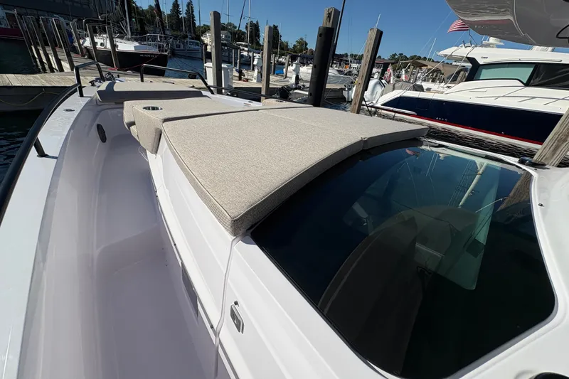 Slide: The Image of 2026 Axopar 37 XC Cross Cabin boat with cushioned deck, docked at marina. - 23