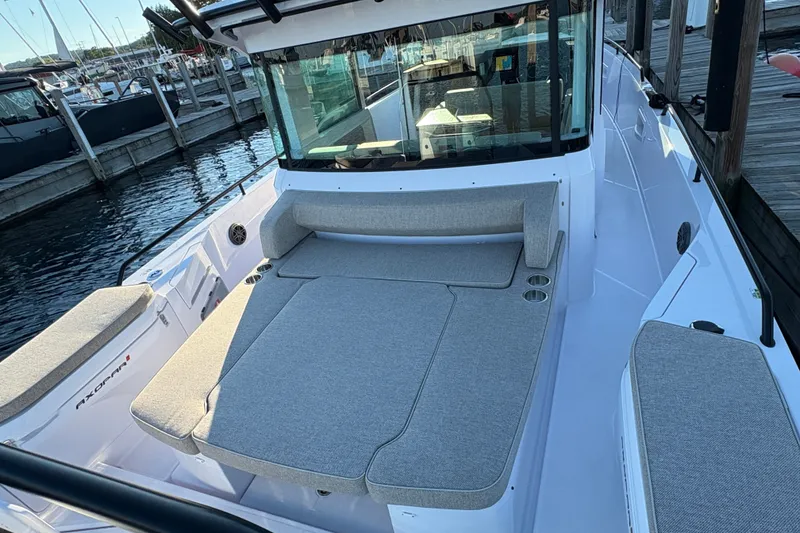 Slide: The Image of 2026 Axopar 37 XC Cross Cabin boat with spacious seating at a marina dock. - 62
