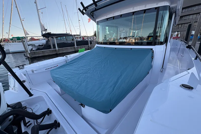 Slide: The Image of 2026 Axopar 37 XC Cross Cabin boat docked, featuring a covered deck area. - 68