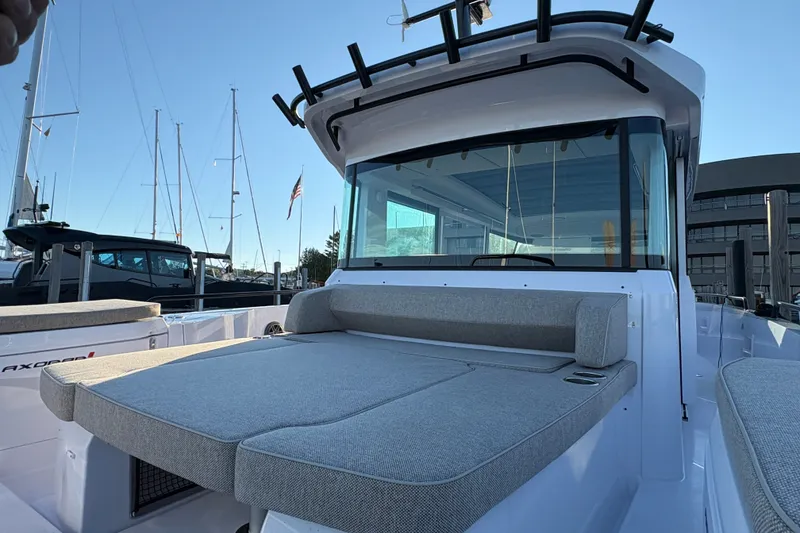Slide: The Image of 2026 Axopar 37 XC Cross Cabin boat with spacious seating and sleek design at a marina. - 61