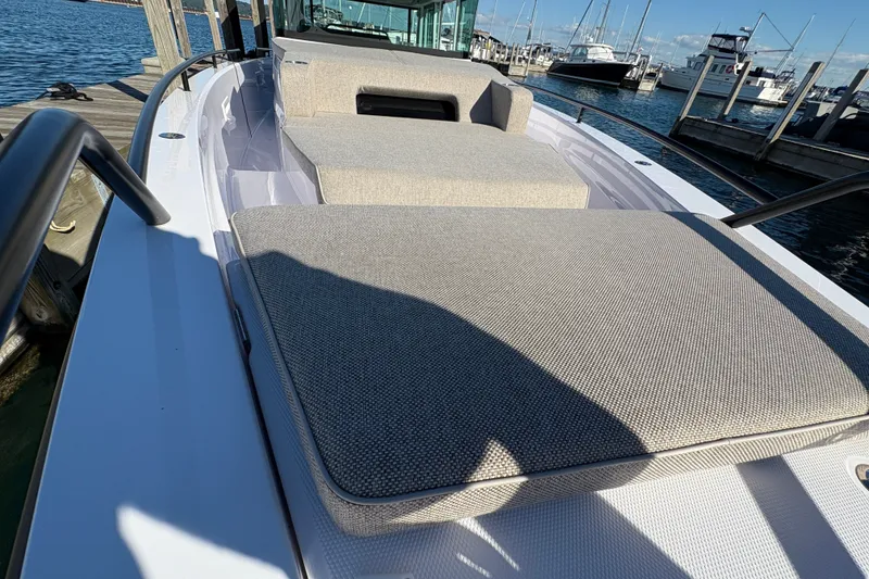 Slide: The Image of 2026 Axopar 37 XC Cross Cabin with cushioned seating, docked at a marina. - 25