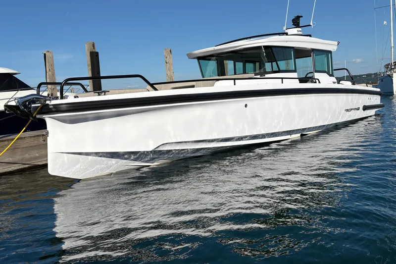 Slide: The Image of 2026 Axopar 37 XC Cross Cabin boat docked on calm water. - 5