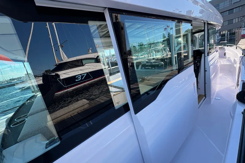 Slide: The Image of 2026 Axopar 37 XC Cross Cabin boat docked, reflecting water and marina surroundings. - 34