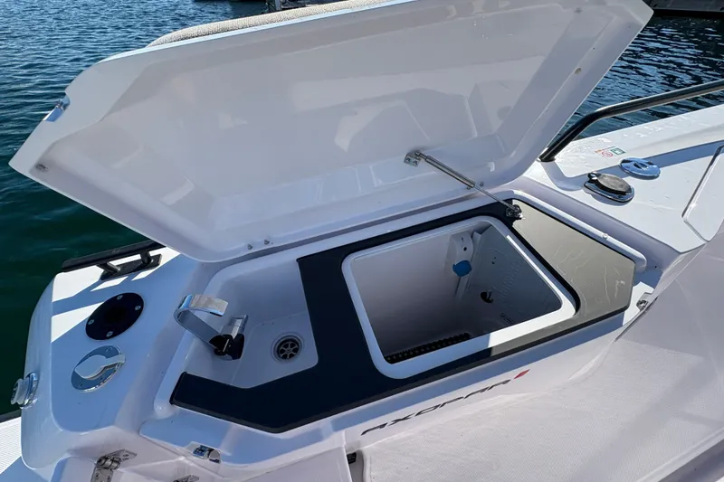 Slide: The Image of Open storage compartment on 2026 Axopar 37 XC Cross Cabin boat, docked on water. - 19