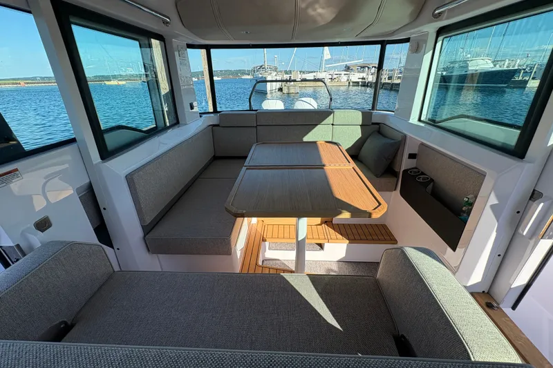 Slide: The Image of Interior of 2026 Axopar 37 XC Cross Cabin with seating and table, docked at marina. - 53
