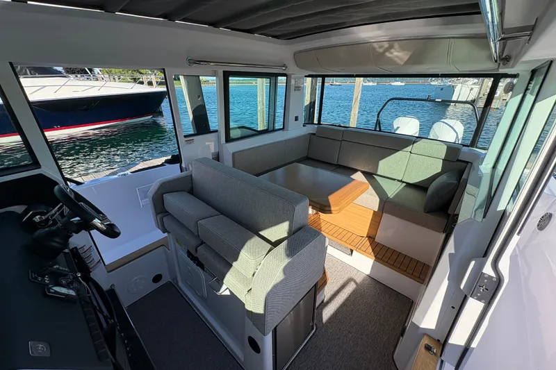 Slide: The Image of Interior of 2026 Axopar 37 XC Cross Cabin with modern seating and waterfront view. - 45