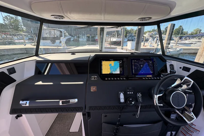 Slide: The Image of Interior view of 2026 Axopar 37 XC Cross Cabin helm with navigation displays. - 37