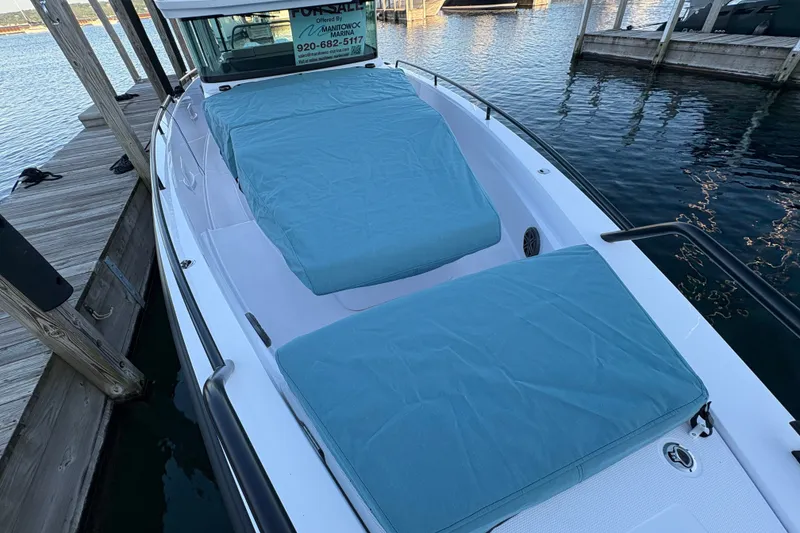 Slide: The Image of 2026 Axopar 37 XC Cross Cabin boat docked with blue cushions on deck. - 66