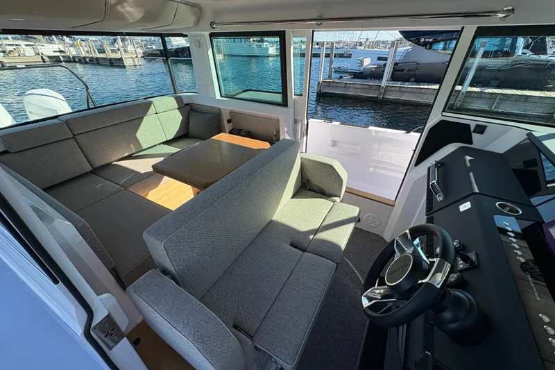 Slide: The Image of Interior of 2026 Axopar 37 XC Cross Cabin with modern seating and helm, dockside view. - 36