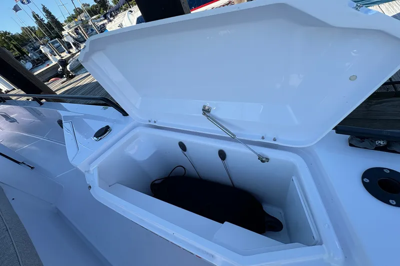 Slide: The Image of Open storage compartment on 2026 Axopar 37 XC Cross Cabin boat docked at marina. - 14