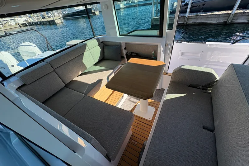 Slide: The Image of Interior of 2026 Axopar 37 XC Cross Cabin with seating and table, dockside view. - 49