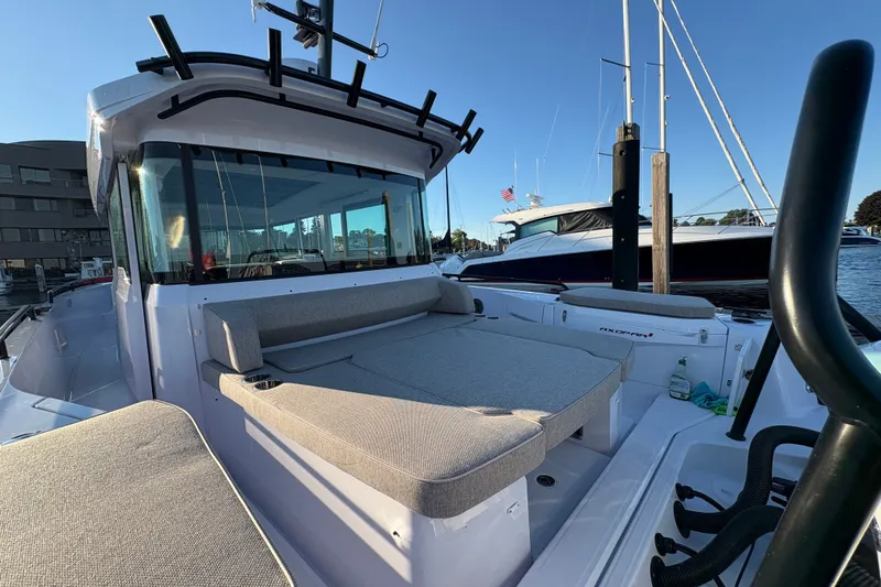 Slide: The Image of 2026 Axopar 37 XC Cross Cabin boat docked, showcasing spacious seating and sleek design. - 63