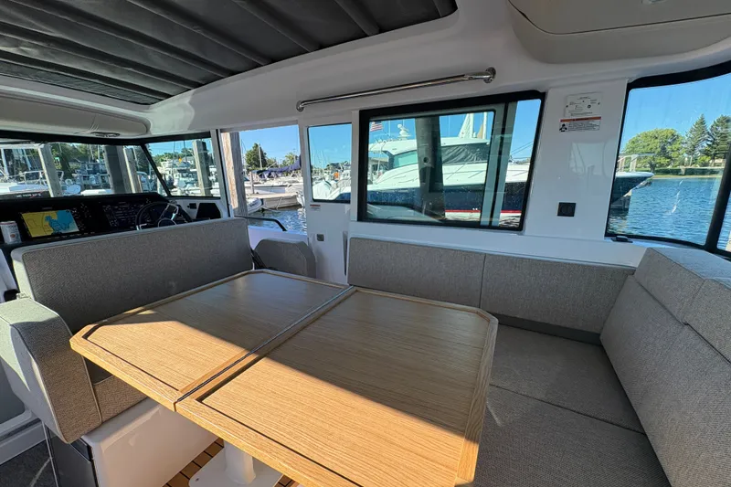Slide: The Image of Interior of 2026 Axopar 37 XC Cross Cabin with seating and table, docked at marina. - 54