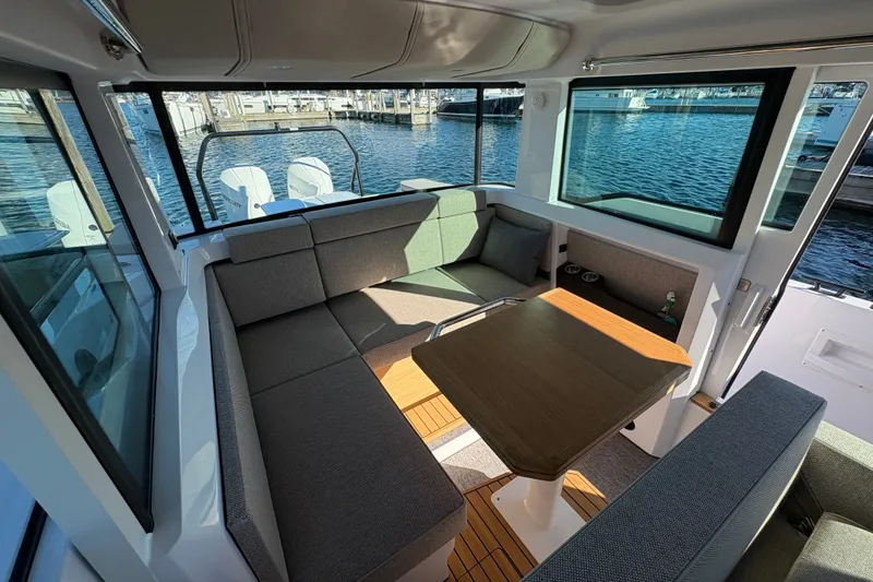 Slide: The Image of Interior of 2026 Axopar 37 XC Cross Cabin with seating and table, overlooking marina. - 46