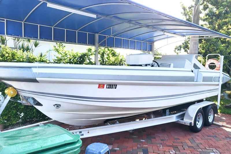 The Image of 2013 NOVURANIA OF AMERICA Chase 23 boat on trailer under blue canopy. - 0