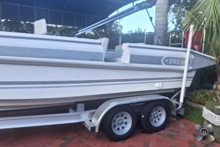Slide: The Image of 2013 NOVURANIA OF AMERICA Chase 23 boat on trailer, parked on brick driveway. - 2