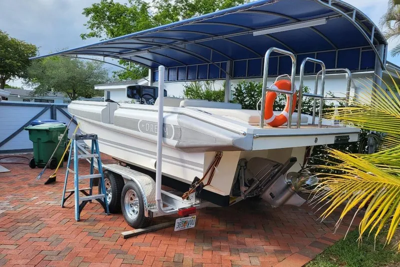 Slide: The Image of 2013 NOVURANIA Chase 23 boat on trailer under canopy, with ladder and life preserver. - 4