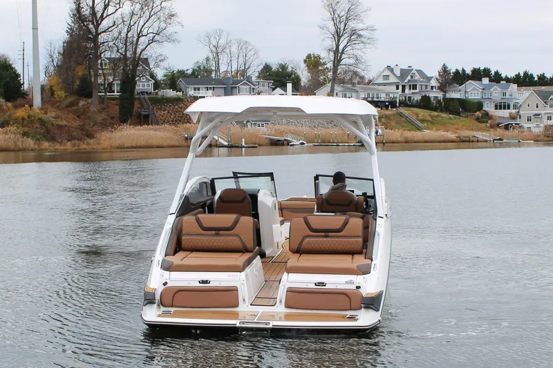 Slide: The Image of 2024 Yamaha 275 SD boat cruising on a serene lake near waterfront homes. - 3