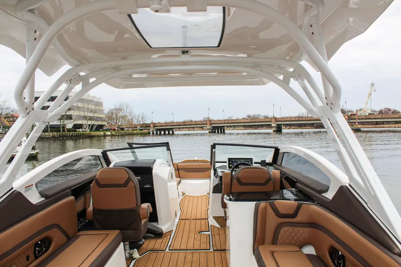 Slide: The Image of 2024 Yamaha 275 SD boat interior with luxurious seating and modern dashboard on a calm river. - 5