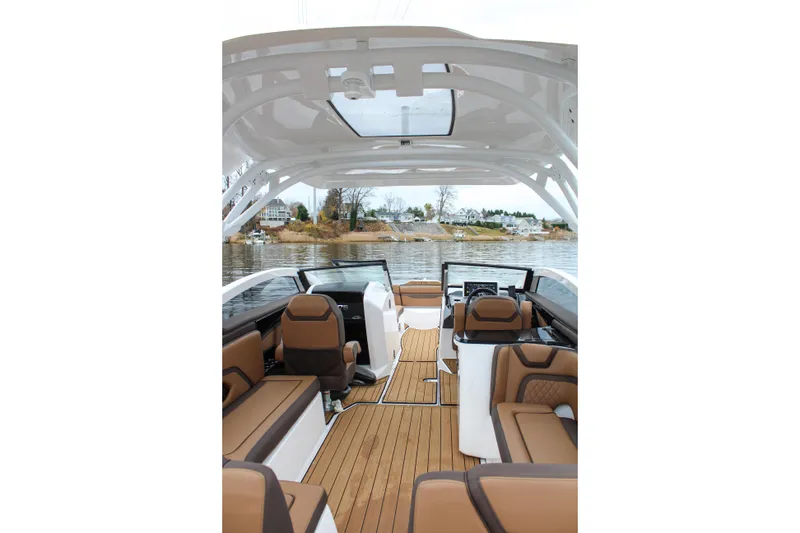 Slide: The Image of 2024 Yamaha 275 SD boat interior with luxurious seating and modern design on a serene lake. - 6